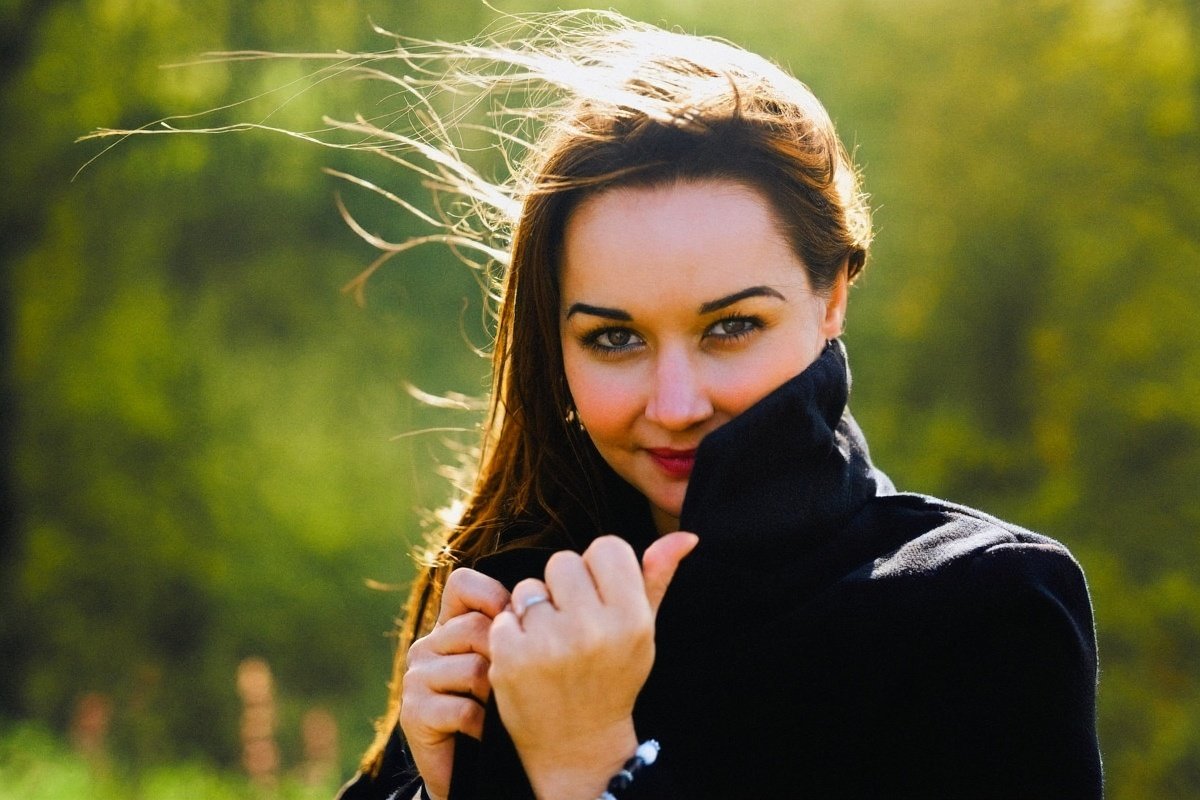 The same portrait in colour, warm skin and green leaves behind her