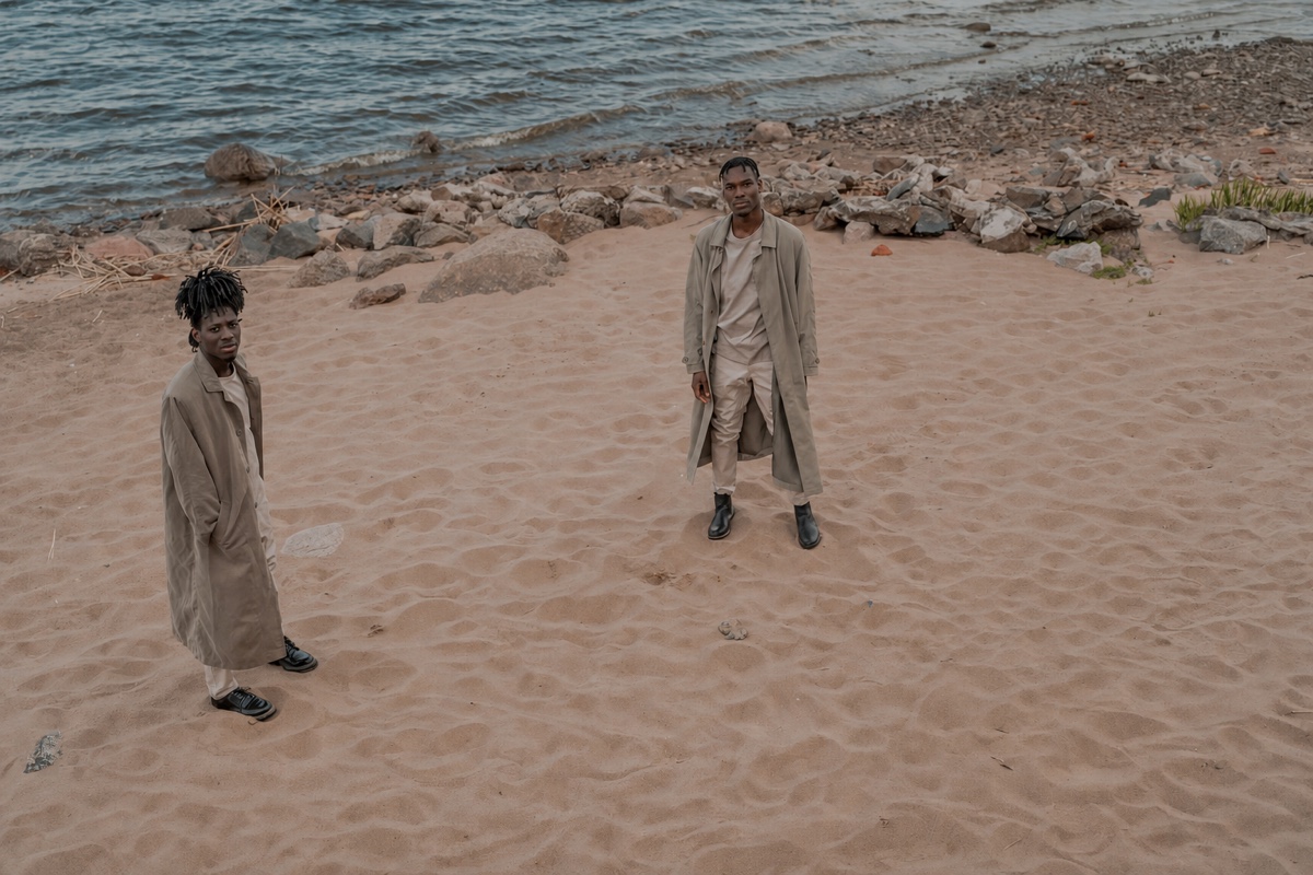 The same shore with the man on the right gone, the rippled sand and the line of rocks behind him unbroken